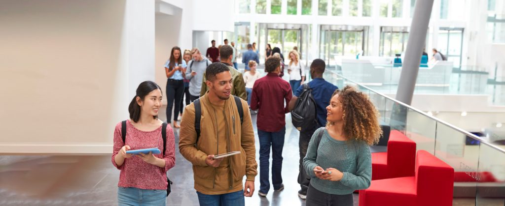 Autism & ADA Adult Services: Young adults interacting in a school hallway