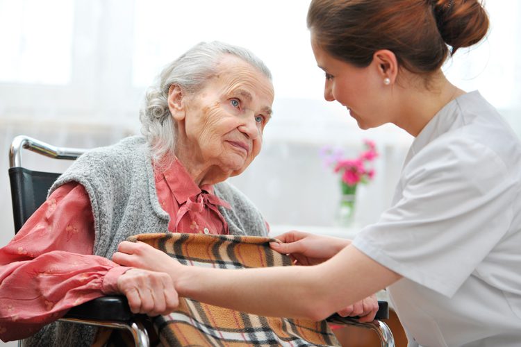 PASSR: Elderly woman in a wheelchair interacting with a female healthcare provider