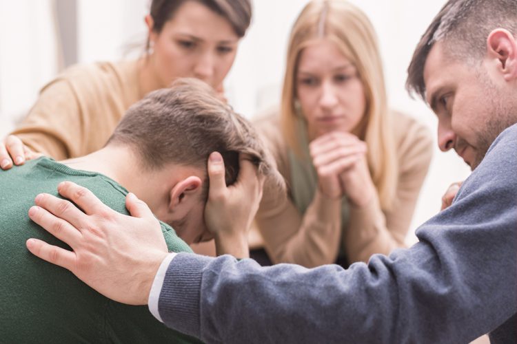 Crisis Intervention: Peers helping a young man through a hard time in a group session