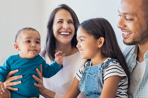 Intervención Temprana en la Infancia (ECI): Una familia joven en un hogar sonriendo juntos