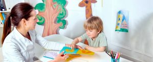 Hero/header image: Autism & ABA: Teacher and student interacting, smiling in a bright classroom setting