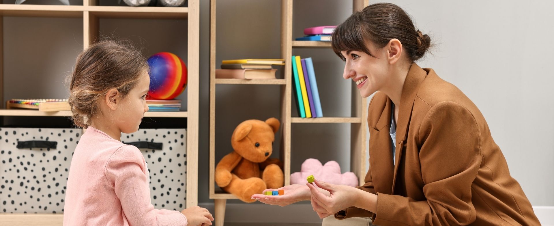 A teacher helping a student learn her colors